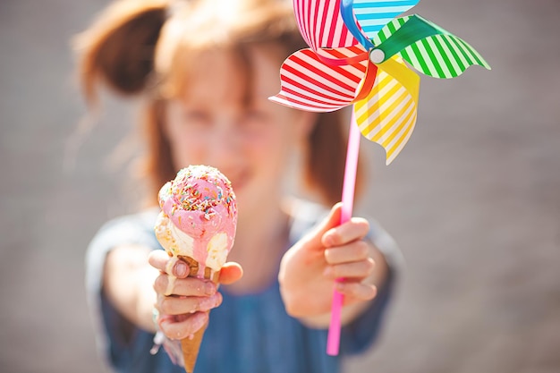 Ragazza carina che mangia il gelato su sfondo estivo all'aperto ritratto del primo piano di adorabile bambina dai capelli rossi che mangia il gelato