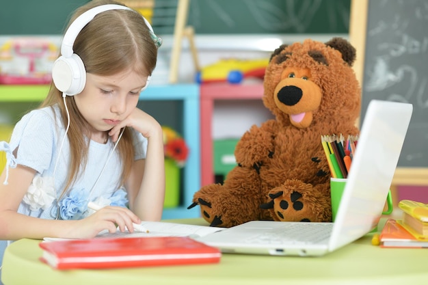 Ragazza carina che utilizza il computer portatile a casa