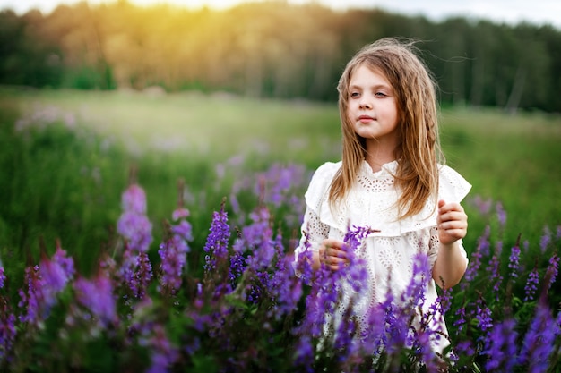 Ragazza carina con fiori in estate