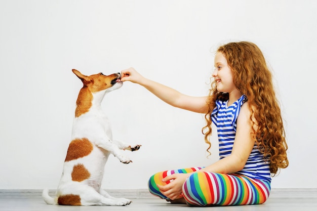 Ragazza carina con giocare il suo cane jack russel terrier.