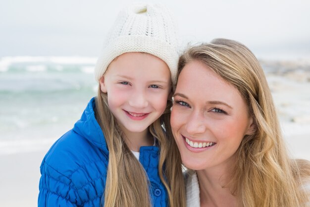 Ragazza carina con sorridente madre in spiaggia