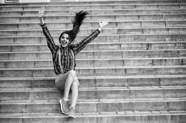 Ragazza carina con un trucco da clown su una foto in bianco e nero di sfondo