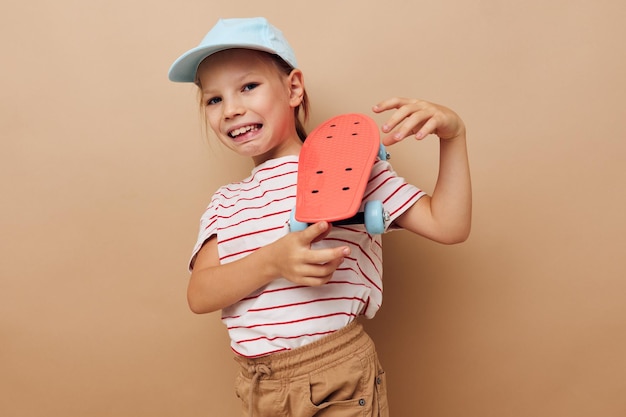 Ragazza carina con uno skateboard per bambini in mano sorriso Stile di vita inalterato