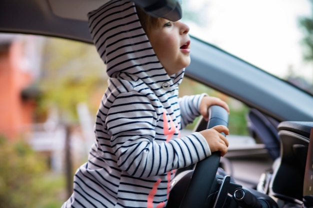 ragazza carina del bambino alla guida di un'auto moderna.