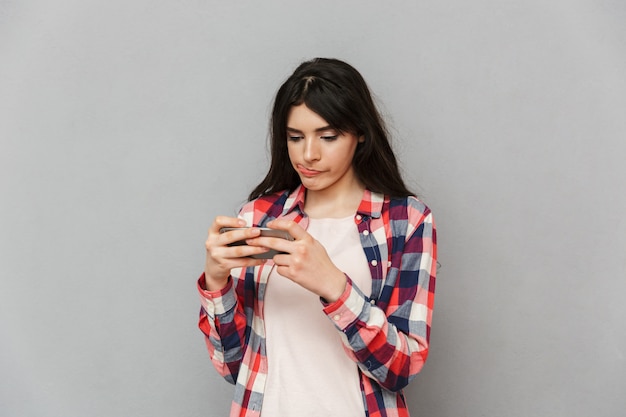 Ragazza carina gioca con il cellulare.