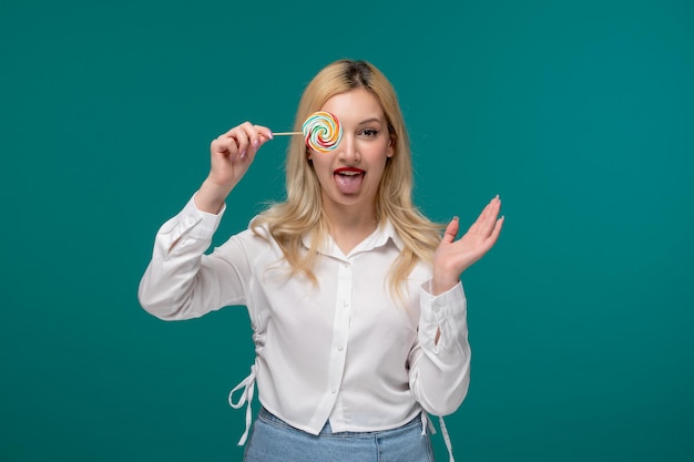 Ragazza carina giovane adorabile ragazza carina in una camicia bianca ordinata che tiene lecca-lecca con la lingua fuori