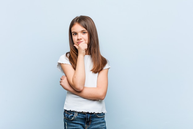 Ragazza carina guardando lateralmente con espressione dubbiosa e scettica.