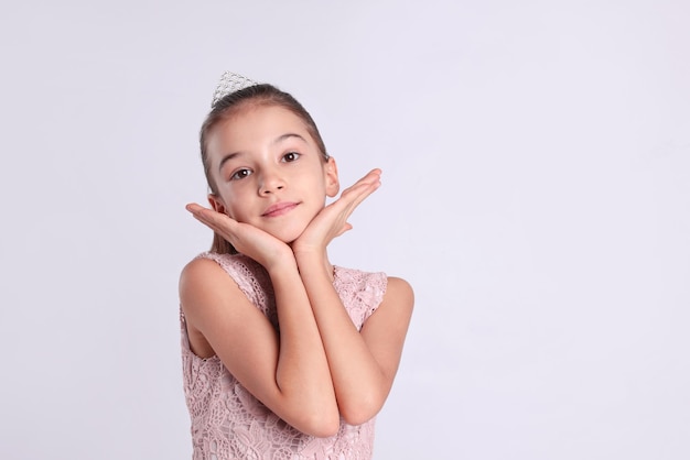 Ragazza carina in diadema su sfondo bianco Piccola principessa