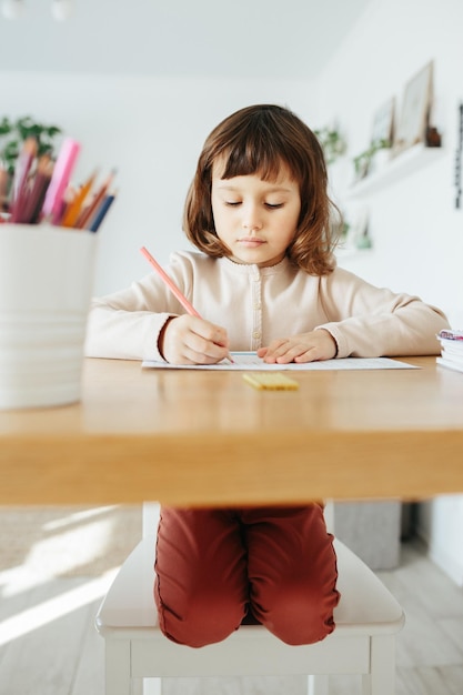 Ragazza carina in età prescolare che impara a casa Apprendimento a distanza di homeschooling per i bambini