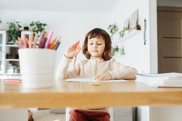 Ragazza carina in età prescolare che impara a casa Apprendimento a distanza di homeschooling per i bambini