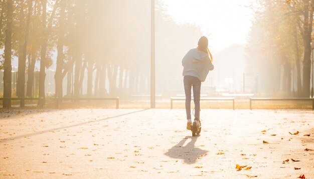 Ragazza carina in piedi da parte sullo scooter nella foschia