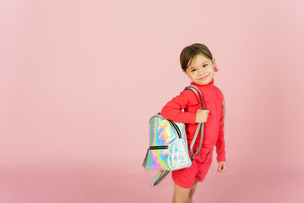 Ragazza carina in un abito rosa in possesso di uno zaino