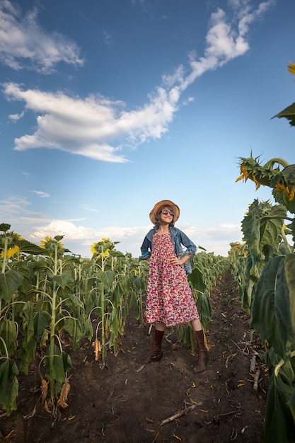 Ragazza carina in un campo di girasoli.