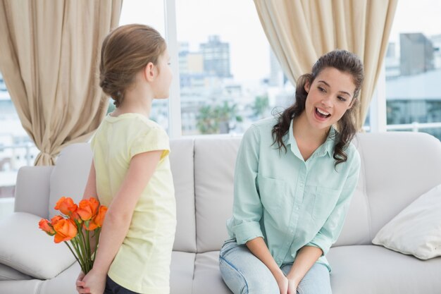 Ragazza carina nascondendo fiori dalla madre