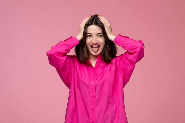 Ragazza carina ragazza adorabile in camicia rosa con rossetto rosso che tiene la testa molto eccitata