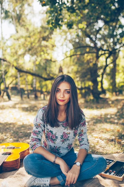 Ragazza carina seduta all'aperto al picnic