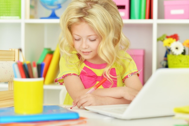 Ragazza carina studentessa con libri e laptop in classe