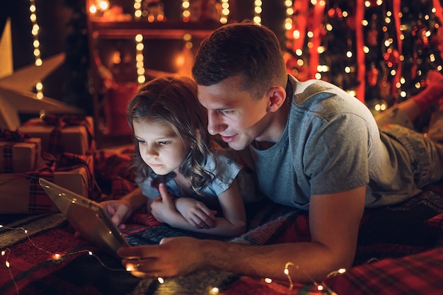 Ragazza carina utilizzando tablet con papà a casa.