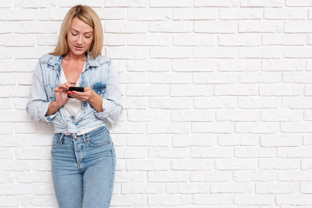 Ragazza casual in denim con telefono