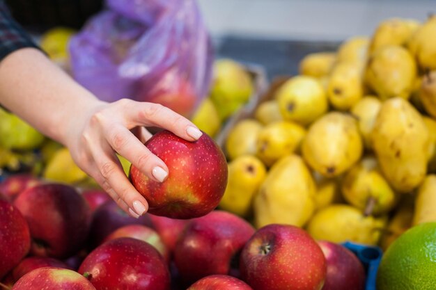 Ragazza caucasica che acquista prodotti alimentari di verdure fresche al marketxA