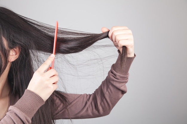 Ragazza caucasica che pettina i suoi capelli.