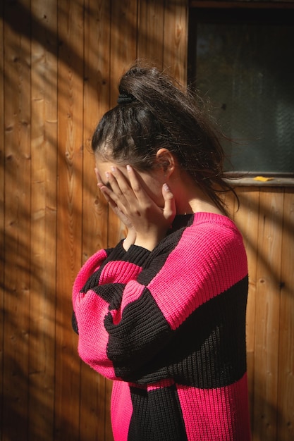 Ragazza caucasica che si copre la faccia.