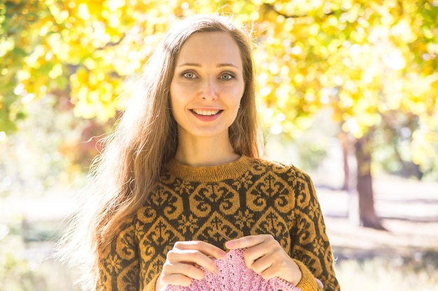 Ragazza caucasica con capelli lunghi in un maglione marrone sorridente