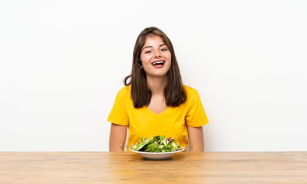 Ragazza caucasica con insalata con espressione facciale a sorpresa