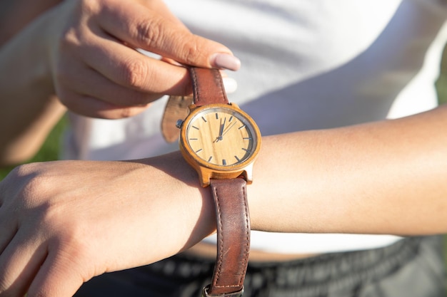 Ragazza caucasica con un orologio da polso in mano