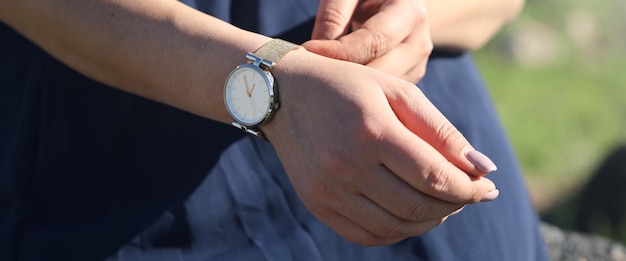 Ragazza caucasica con un orologio da polso in mano