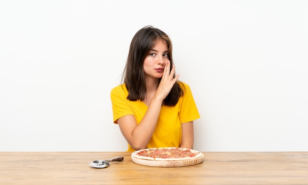 Ragazza caucasica con una pizza che bisbiglia qualcosa