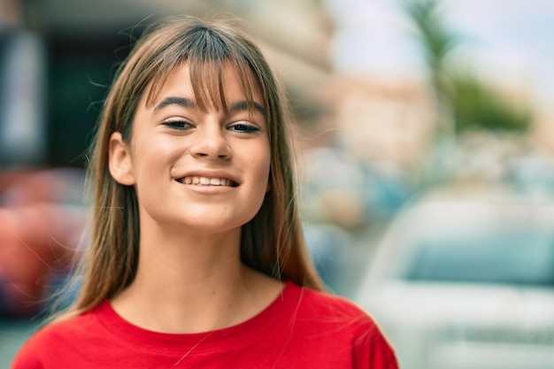 Ragazza caucasica dell'adolescente che sorride felice che sta alla città.