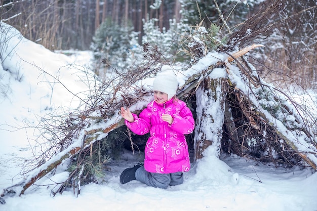 Ragazza caucasica di 5 anni che gioca nella foresta invernale, trascorrendo del tempo all'aperto in inverno