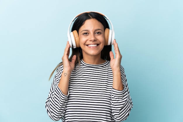 Ragazza caucasica isolata sulla musica d'ascolto blu