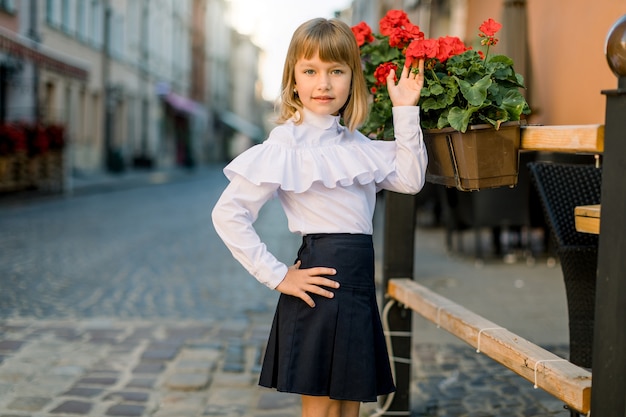 Ragazza caucasica toccando fiore rosso