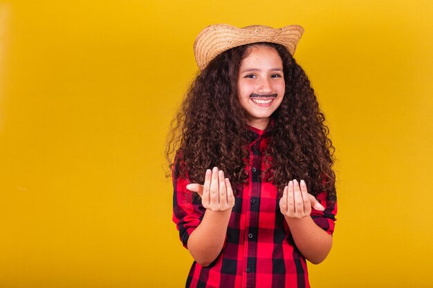 Ragazza caucasica vestita da ragazzo vestiti da festa che chiamano con le mani vengono qui Festival a maggio, giugno e luglio