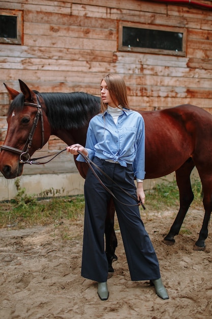 Ragazza cavaliere in piedi accanto al cavallo