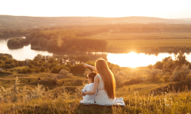 Ragazza che abbraccia il fratellino sulla collina al tramonto