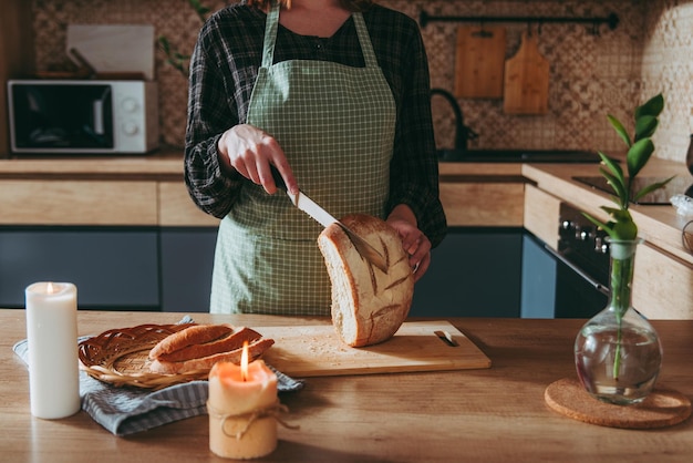 ragazza che affetta il pane, cucina casalinga, sfondo della cucina