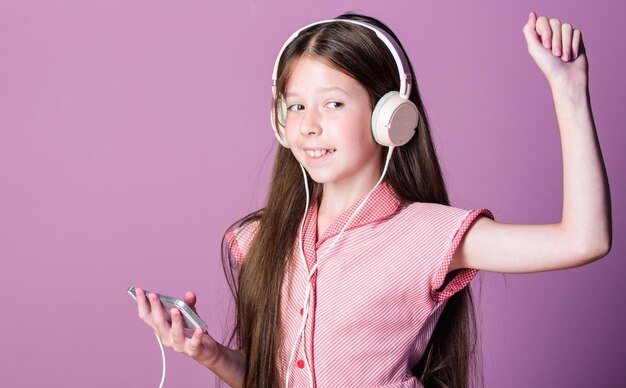 Ragazza che balla ascolta musica Audiolibro torna a scuola bambino studio online E apprendimento con ebook scuola a casa piccola ragazza allievo in cuffia autoeducazione lettore Mp3