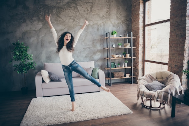 ragazza che balla divertendosi nel soggiorno interno moderno loft in stile industriale al chiuso