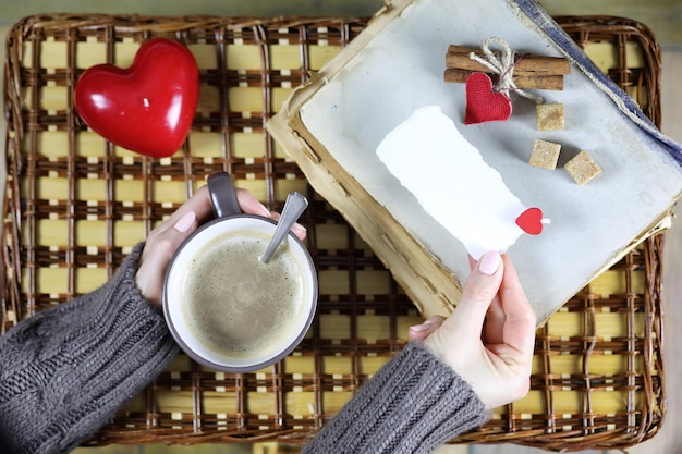 ragazza che beve caffè e guarda il biglietto di San Valentino