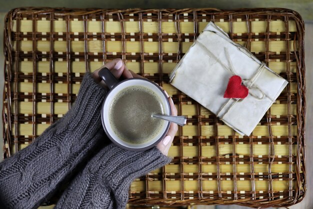 ragazza che beve caffè e guarda il biglietto di San Valentino