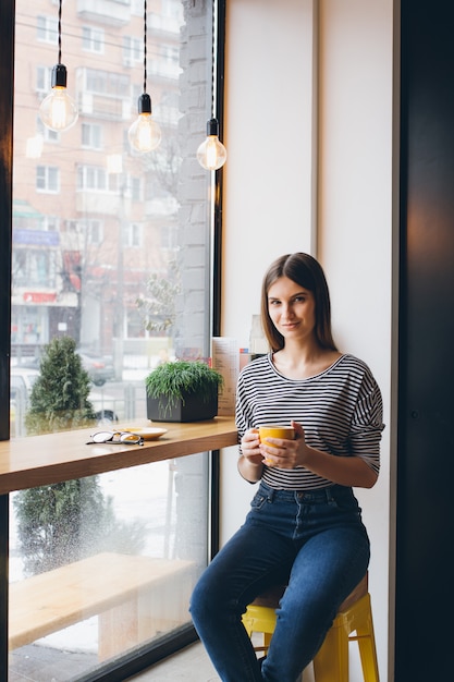 Ragazza che beve il caffè in una caffetteria