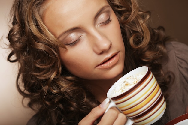 Ragazza che beve tè o caffè