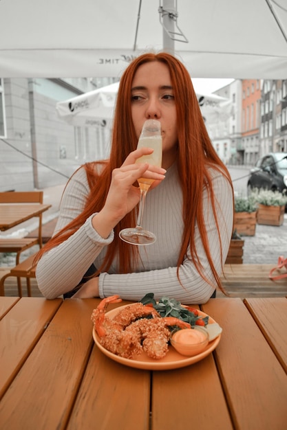 Ragazza che beve un cocktail e mangia tempura