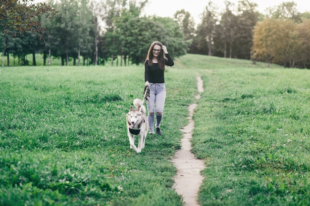 Ragazza che cammina con il suo cane nel parco