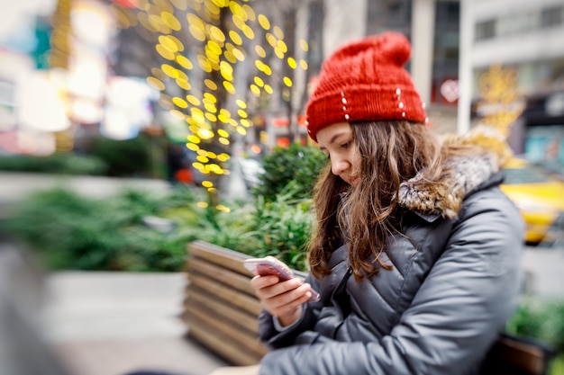 Ragazza che cammina e manda un SMS sul suo smartphone