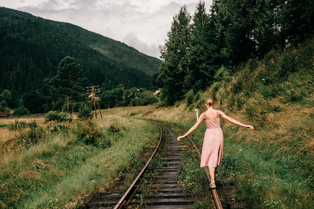 Ragazza che cammina sulla ferrovia