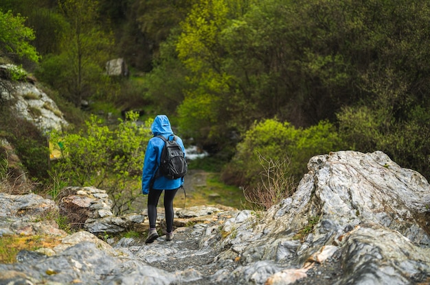 Ragazza che cammina sulla montagna mentre piove